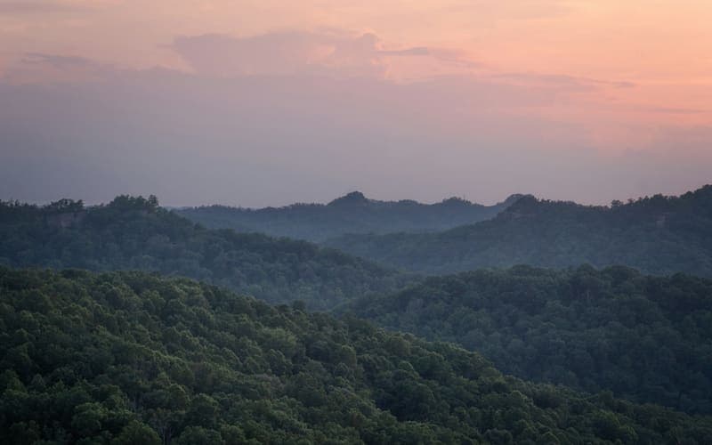 Forested ridges receding into a pink evening sky in the Red River Gorge, Kentucky